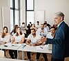 Studierende und Professor in einer Präsenzvorlesung 