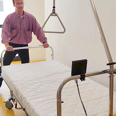 Masterand Oliver Fleck mit wiegendem Bett